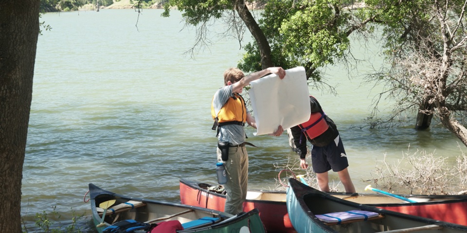 Scouts planning their canoeing trip on a lake